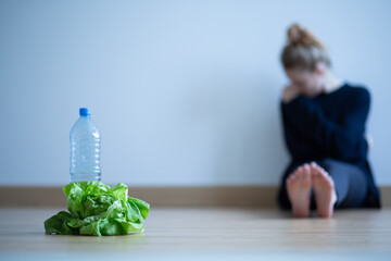 Teenager girl with anorexia nervosa being on restricted diet of water and salad