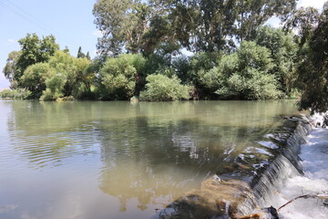 Dam and waterfall and shrubs in the Jordan River near Kibbutz Kfar Blum in Israel