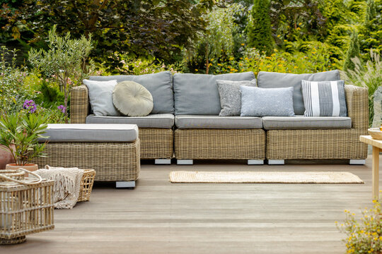 Grey Pillows On Trendy Wicker L Shape Sofa In The Green Garden