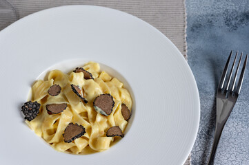 Dish of delicious italian pasta tagliatelle with truffle mushroom chips