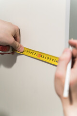 builder measures the surface with a measuring tape