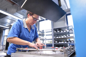 Woman working in the production of a factory for electronics