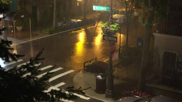 Medium Wide: Downpour at night on Beekman Place, New York City.
