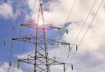 Power transmission tower against the sky, illuminated by the sun. Selective focus blur.