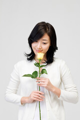 young woman holding yellow rose