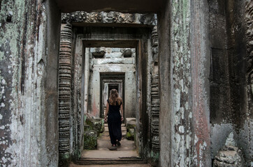 Female traveler in ruins in Angkor Wat temple, ancient Khmer Empire, Siem Reap, Cambodia