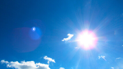 Naklejka na ściany i meble sun on the background of a blue sky with white clouds