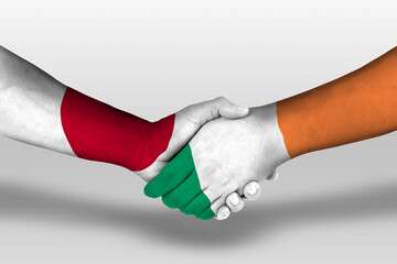 Handshake between ireland and japan flags painted on hands, illustration with clipping path.