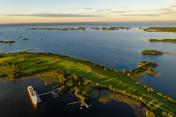 panoramic view of the lake with many islands on one of them there is an ancient temple made of wood at sunset filmed from a drone