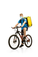 Obraz na płótnie Canvas Deliveryman in face mask with bicycle isolated on white studio background. Contacless service during quarantine. Man delivers food during isolation. Safety. Professional occupation. Copyspace for ad.