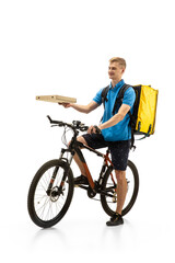 Obraz premium Giving pizza. Deliveryman with bicycle isolated on white studio background. Contacless service during quarantine. Man delivers food during isolation. Safety. Professional occupation. Copyspace for ad.