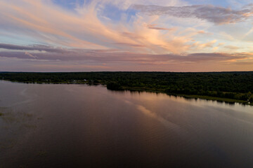 panoramic view of the lake with many islands on one of them there is an ancient temple made of wood at sunset filmed from a drone