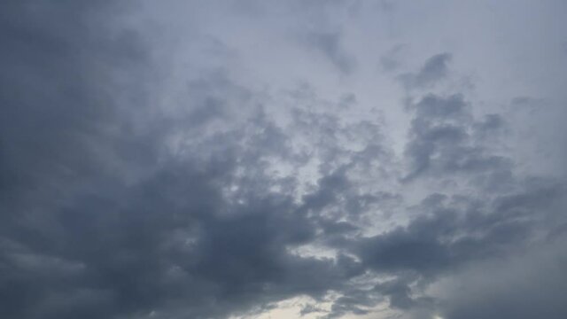 Dramatic b-roll TimeLapse of dark storm clouds & gray cumulus or cirrocumulus cloudscape slowly moved on bright sunrise sky with sun light rays & sunbeam shining through tropical summer horizon  
