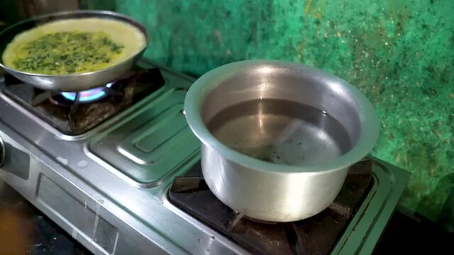 Opening The Stove Using Kitchen Gas Lighter And Place A Pot With Water. - Wide Shot