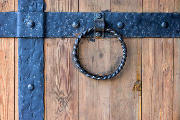 Old wooden door wrought iron and metal round handle