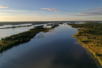 panoramic view of the lake with many islands on one of them there is an ancient temple made of wood at sunset filmed from a drone