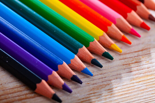 Image of multicolored wooden pencils on wooden surface
