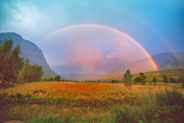 Beautiful rainbow over mountain valley at sunset. Birtavarre, Norway, Europe