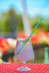 Lavander lemonade drink in a glass with plastic straw outside. Fresh natural organic herbal soft drink.