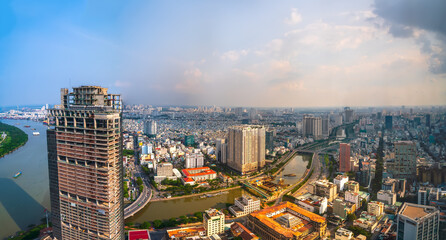 Naklejka premium High view Saigon central skyline when afternoon down urban areas with tall buildings along river showing development country in Ho Chi Minh City, Vietnam