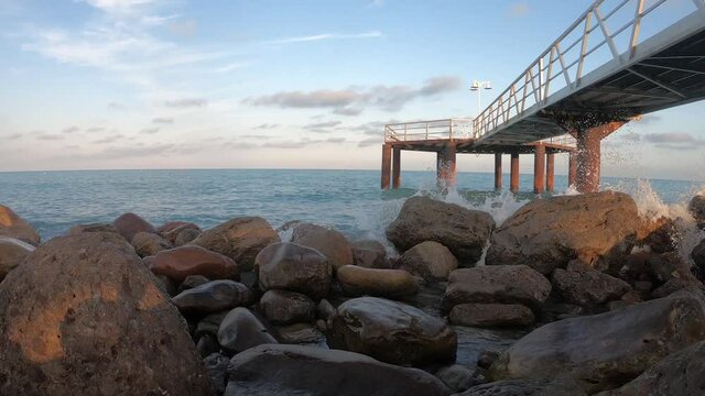 V&iacute;deo de las rocas del mar con las olas y un muelle de madera