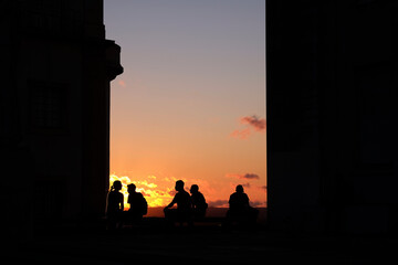 Silhouette of people sitting while watching the sunset in Coimbra, Portugal 