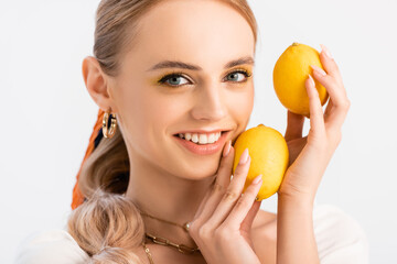 blonde woman posing with yellow lemons isolated on white