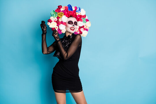 Photo of creepy monster zombie lady dreamy dance latin vibes pretend have maracas give rythm wear black short mini dress death costume roses headband isolated blue color background