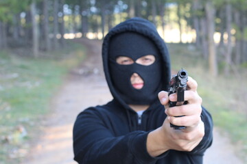 Bandit holding a gun in the forest