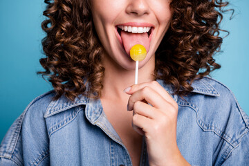 Close up cropped photo of positive cheerful girl lick tongue lollipop enjoy summer free time wear...