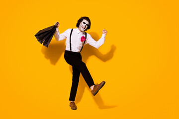 Fototapeta na wymiar Full length body size view of his he nice handsome spooky cheerful cheery ecstatic excited glad guy gentleman carrying buyings having fun isolated bright vivid shine vibrant yellow color background
