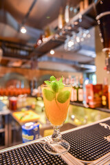 Refreshing cold citrus drink with mint. Cold summer beverage served in a glass. ALcohol cocktail on a wooden table