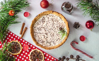 Homemade tart decorated with cocoa on a white table with pine branches. Table decoration for Christmas and new year