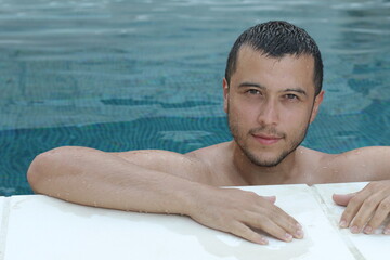 Ethnic man relaxing in swimming pool 
