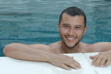 Ethnic man relaxing in swimming pool 
