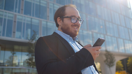 Cheerful overweight office worker surfing internet relaxing near business center.