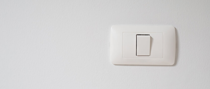 Electronic lighting switch with white wall background. home electrical power.