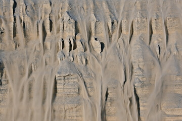 the texture of the sand is drowned by sand dunes / sand avalanche is showered off the dune, an unusual texture of sand