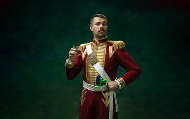 Royal whiskey. Young man in suit as Nicholas II isolated on dark green background. Retro style,...