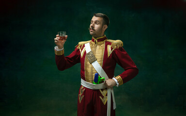 Royal whiskey. Young man in suit as Nicholas II isolated on dark green background. Retro style,...