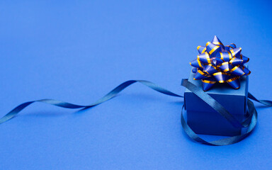 classic blue surprise gift box with blue ribbon, background with copy space