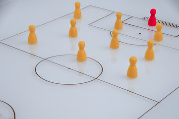 Whiteboard with scheme closeup football game with wooden game pieces