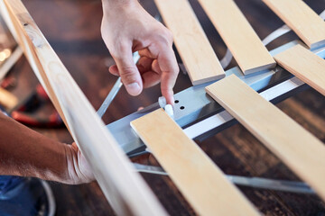 Carpenter hobbyist assembling wooden boards at home / garage.