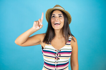 Young beautiful woman wearing swimsuit and hat over isolated blue background surprised and thinking with her finger on her head that she has an idea.