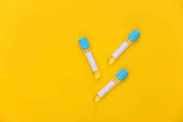 Medical test tubes on yellow background. Top view