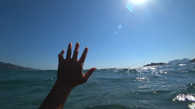 Iztuzu Beach, Dalyan, Turkey - 17th of August 2020: 4K In stormy sea a hand waving for help as seen by the drowing person
