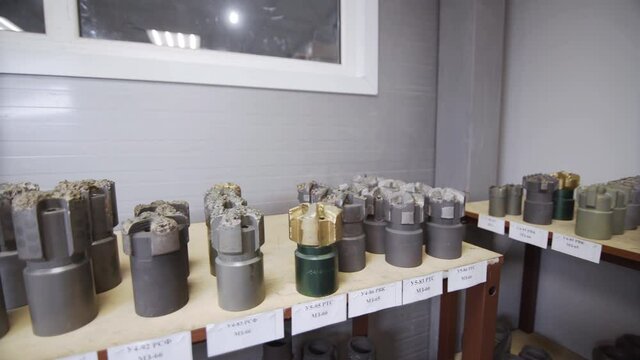 Drill Bits on shelving in stock. Oil drilling equipment for drilling rig operation on oil platform in oil and gas industry. Brand new PDC Polycrystalline Diamond Compact drilling bit