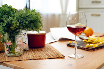 Wine glass and vegetables on wooden kitchen table