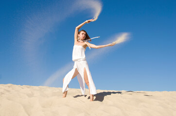 Fototapeta na wymiar girl dancing and playing with sand 