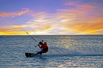 Kite surfing at Palm Beach on Aruba island in the Caribbean Sea at sunset